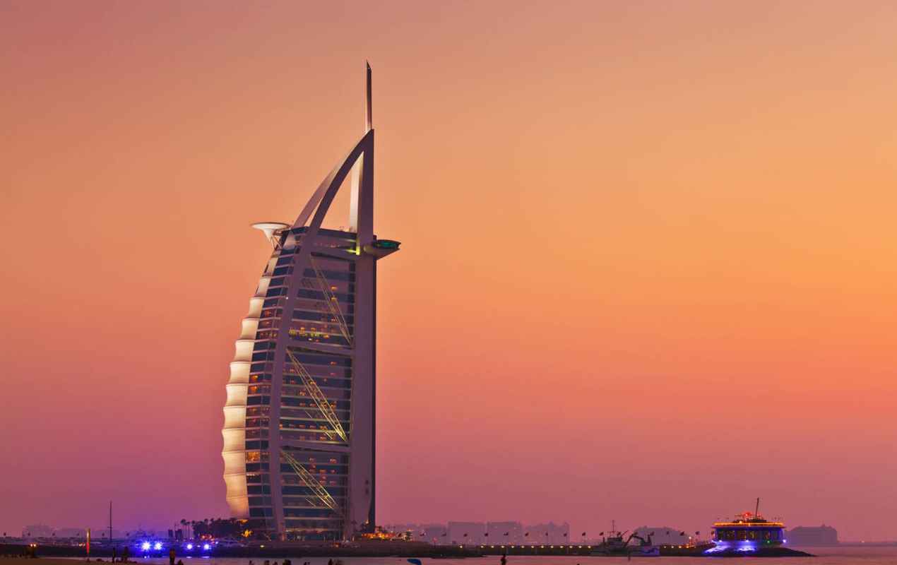 Dubai Burj al Arab hotel with sunset lit up at night Dubai, United Arab Emirates, UAE.