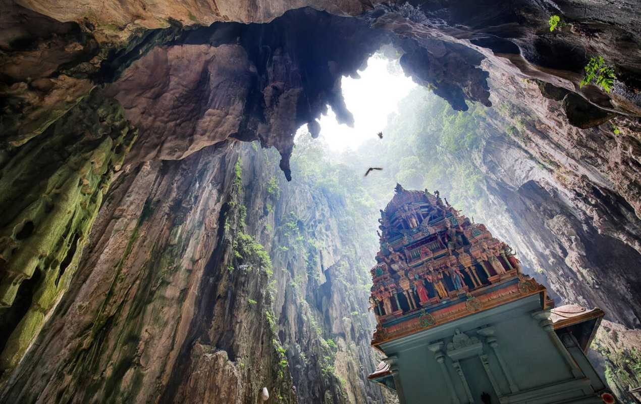 Birds flying over the Hindu temple in the Batu Caves, Kuala Lumpur.